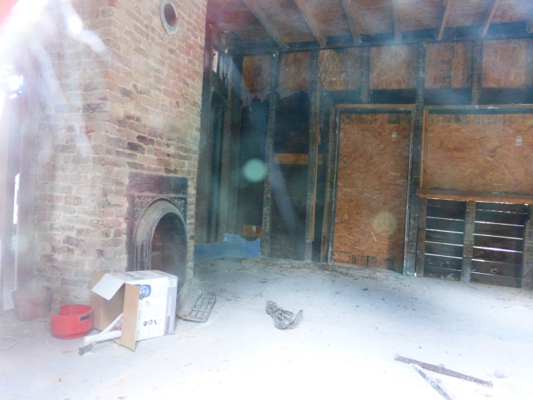 Right/west side of the house, looking toward the center of the home where an old fireplace sits.