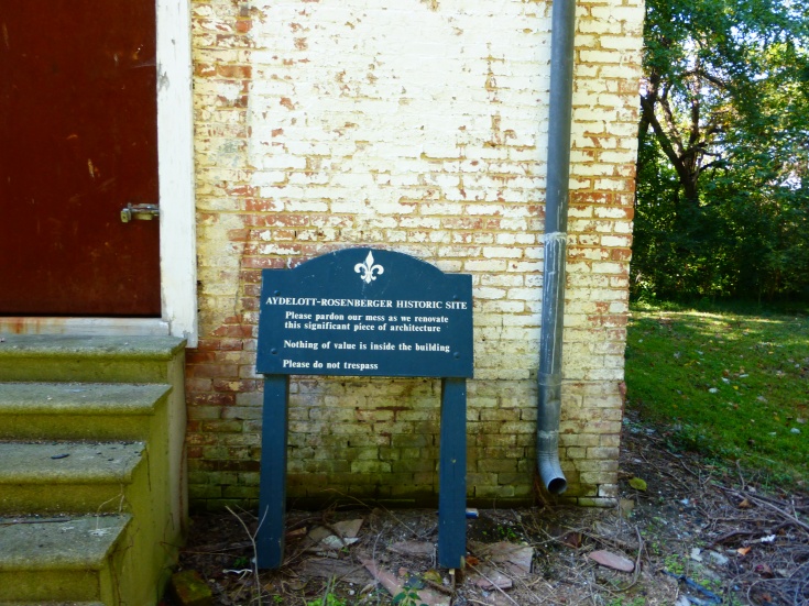 Interpretive sign sitting against the old whitewashed brick.
